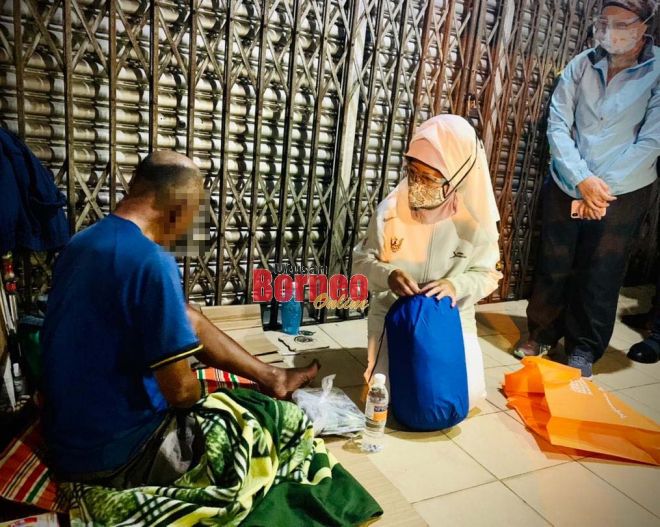 Fatimah menyampaikan bantuan kepada seorang gelandangan di sekitar pusat Bandar Raya Kuching, malam Rabu