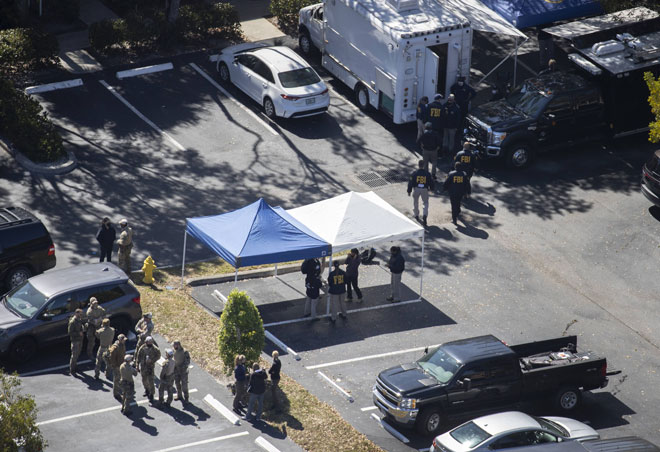  Anggota penguat kuasa undang-undang memeriksa tempat di mana dua ejen FBI ditembak mati ketika menjalankan tugas di Sunrise, Florida kelmarin. — Gambar AFP