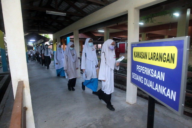  Calon-calon Sijil Pelajaran Malaysia (SPM) 2020 bergerak menuju ke dewan peperiksaan ketika tinjauan di sekolah sekitar Putrajaya hari ini. - Gambar Bernama