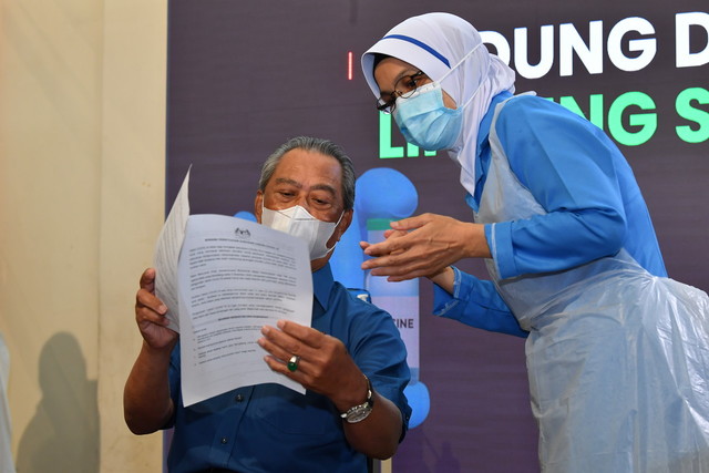 Muhyiddin menjadi individu pertama di negara ini menerima vaksin COVID-19 jenis Pfizer-BioNTech pada Program Imunisasi COVID-19 Kebangsaan di Pusat Kesihatan Daerah Putrajaya, Presint 11, hari ini. - Gambar Bernama