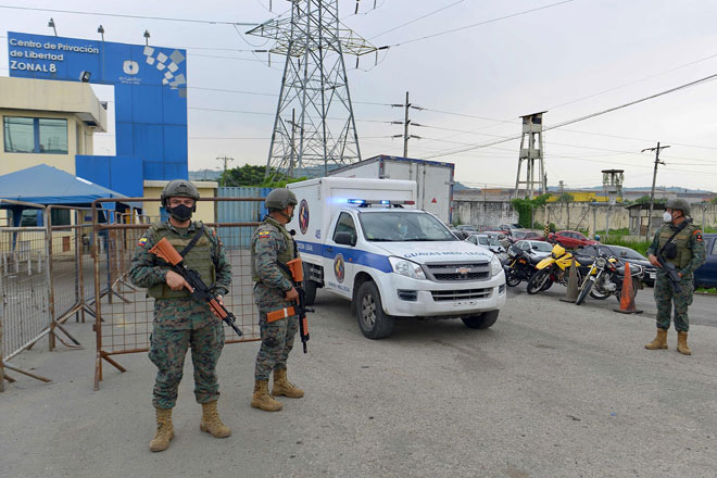  Anggota pasukan keselamatan berkawal ketika ambulans bergerak keluar dari Pusat Tahanan Guayaquil selepas rusuhan ganas meletus kelmarin. — Gambar AFP