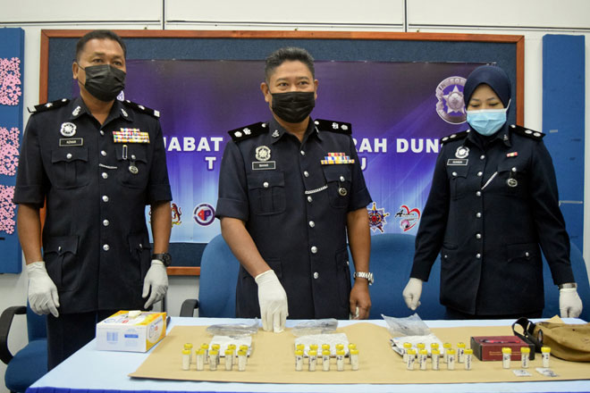  Supt Baharudin (tengah) menunjukkan dadah jenis heroin dan syabu bernilai RM22,150 yang dirampas dalam satu serbuan di ladang kelapa sawit di Felda Kerteh 3, Ketengah Jaya pada sidang media di Ibu Pejabat Polis Daerah Dungun, dekat Dungun semalam. — Gambar Bernama