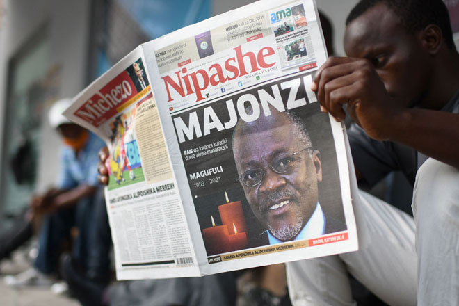  Seorang lelaki membaca surat khabar yang melaporkan berita kematian Magufuli di muka depannya di Dar Es Salaam semalam. — Gambar AFP 