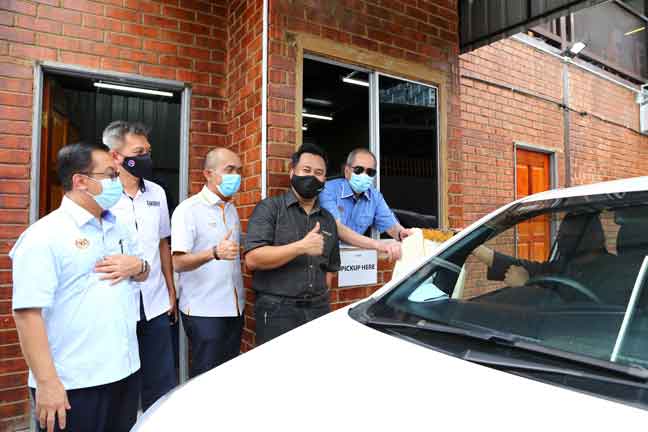  Wan Junaidi (kanan) cuba memberikan pesanan melalui pandu lalu bersama pemilik restoran Syarifuddin Misjan (dua, kiri) pada lawatan kerjanya di Al Mizan Satay Housei, Johor Bahru, semalam. — Gambar Bernama