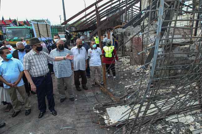  Wan Junaidi meninjau kawasan kejadian kebakaran ketika mengadakan lawatan di Pasar Datuk Keramat, Kuala Lumpur semalam. Lebih 40 kedai di pasar itu terbakar dalam kejadian pada petang 17 Mac lepas namun tidak membabitkan sebarang kemalangan jiwa.  — Gambar Bernama