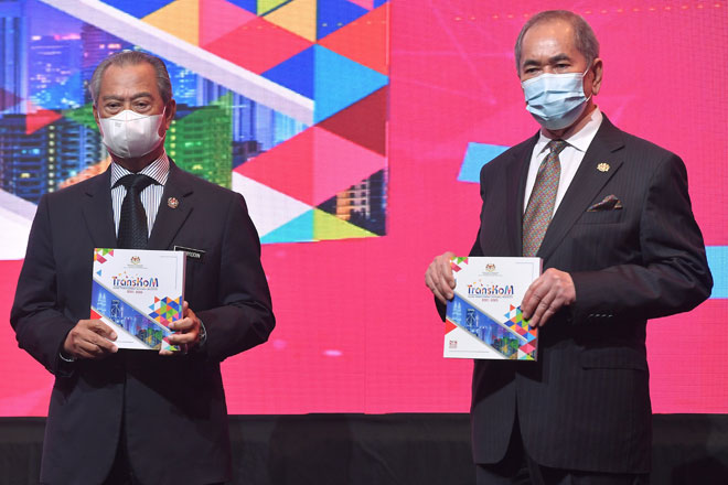  Muhyiddin bersama Wan Junaidi (kanan) bergambar dengan buku Pelan Transformasi Koperasi Malaysia 2021-2025 (TransKoM) yang dilancarkan di Kuala Lumpur, semalam. — Gambar Bernama