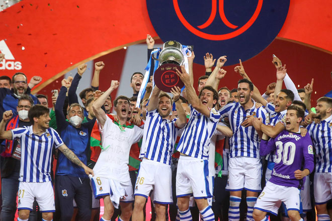  Pemain dan kru pasukan Real Sociedad meraikan kejayaan mereka di atas podium dengan menjulang trofi kejuaraan selepas menewaskan Athletic Bilbao 1-0 pada final Copa del Rey di Stadium La Cartuja, Sevilla. — Gambar AFP