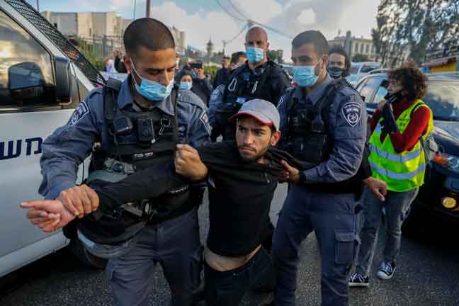  Anggota polis Israel menahan seorang aktivis warga Israel semasa demonstrasi di Jerusalem. — Gambar AFP