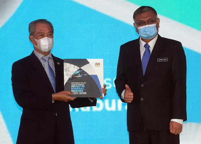 Muhyiddin menunjukkan buku Kerangka Pelan Transformasi Industri Mineral Negara 2021-2030 pada majlis pelancaran pelan transformasi itu hari ini. Turut hadir Menteri Tenaga dan Sumber Asli Datuk Seri Dr Shamsul Anuar Nasarah (kanan). - Gambar Bernama