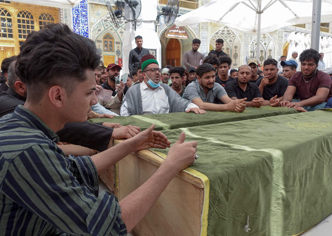  Ahli keluarga dan sanak saudara meratapi mangsa tragedi kebakaran Hospital Ibn Al-Khatib semasa perarakan pengebumian di makam Imam Ali di Najaf, kelmarin. — Gambar AFP
