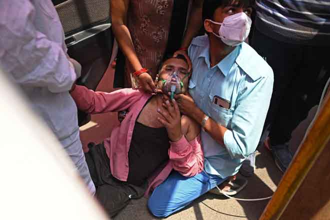  Seorang lelaki bernafas dengan bantuan peralatan oksigen yang disediakan oleh Gurdawara, sebuah rumah ibadat Sikh, di Ghaziabad kelmarin. — Gambar AFP