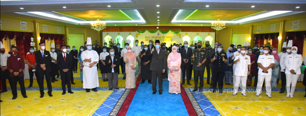  Tun Juhar (tengah, depan) menunjukkan isyarat terbaik ketika merakam gambar bersama rombongan penyumbang kek hari raya.