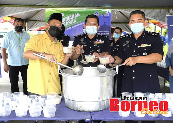  Sahran (kiri) bersama Mazli (tengah) sedang membuat persiapan untuk membungkus bubur lambuk yang siap dimasak sempena program itu.