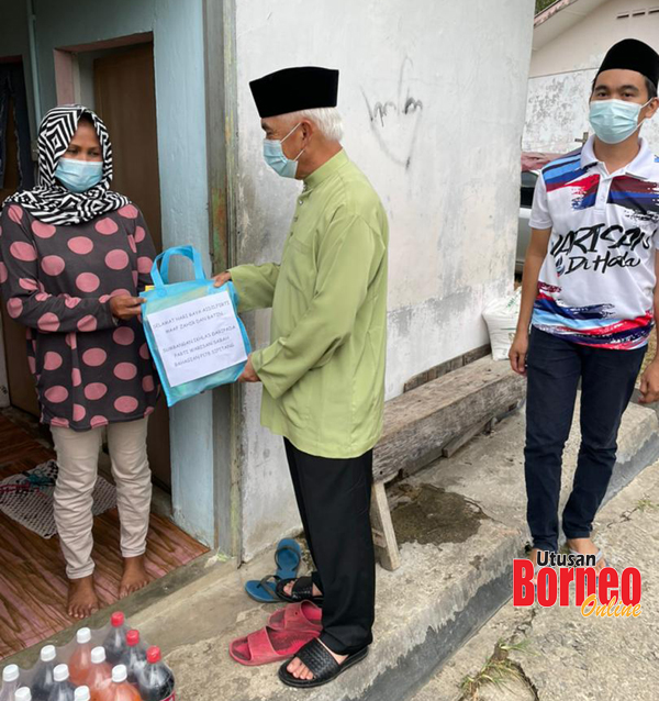  Dr Yusop (tengah) diiringgi Mohd. Sharif (kanan) menyampaikan sumbangan Aidilfitri kepada seorang penduduk di Kg. Gadong.