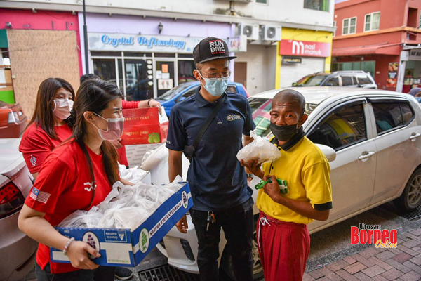  Vivian (kiri) bersama pasukannya telah mengedarkan hidangan pasta sumbangan Pasta Mammamia Sandakan kepada gelandangan di sekitar Bandar Sandakan.