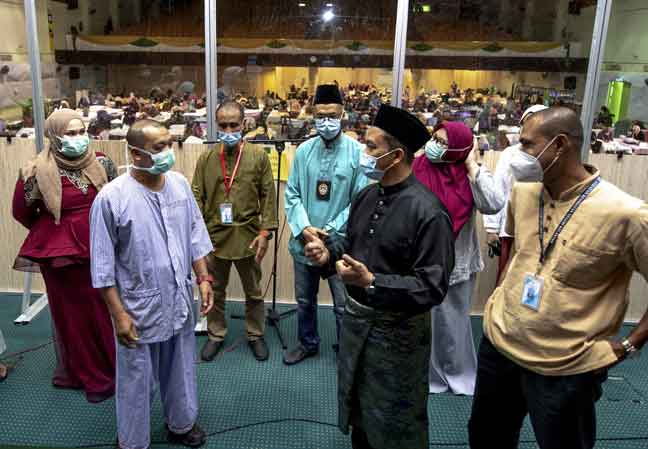  Dr Mohd Azman (dua kanan) bertanya sesuatu kepada seorang pesakit sempena tinjauan di Pusat Kuarantin dan Rawatan COVID-19 Berisiko Rendah (PKRC) Negeri Kelantan semalam. — Gambar Bernama