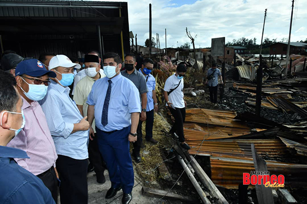  Hajiji (tiga kiri) melawat lokasi kebakaran di Kg Meruntum, turut kelihatan ialahMenteri Pembangunan Masyarakat dan Kesejahteraaan Rakyat Sabah, Shahelmey Yahya (empat kiri) yang juga Ahli Dewan Undangan Negeri (ADUN) Tanjung Keramat.