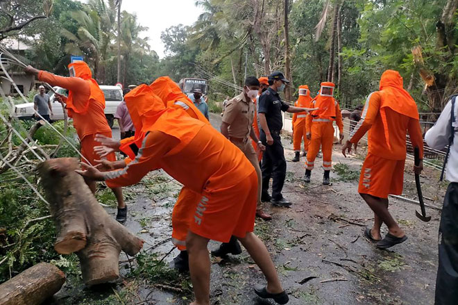  Gambar serahan oleh Pasukan Respons Bencana Antarabangsa (NDRF) menunjukkan kakitangan NDRF bertungkus lumus mengalihkan pokok tumbang di atas jalan raya selepas dibadai Siklon Tauktae di Margao, Goa, kelmarin. — Gambar AFP