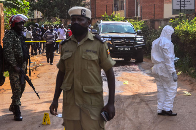  Anggota polis memeriksa kawasan di mana kenderaan Wamala diserang empat suspek menunggang motosikal yang membunuh anak perempuannya dan seorang pengawal peribadi di Kampala, Uganda kelmarin. — Gambar AFP