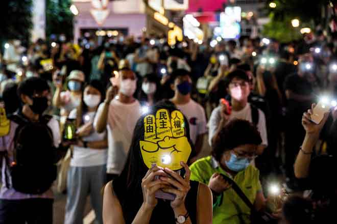  Penduduk menyalakan lampu telefon bimbit dan menyalakan lilin di sekitar bandar di Hong Kong sebagai menandakan tarikh tersebut. — Gambar AFP