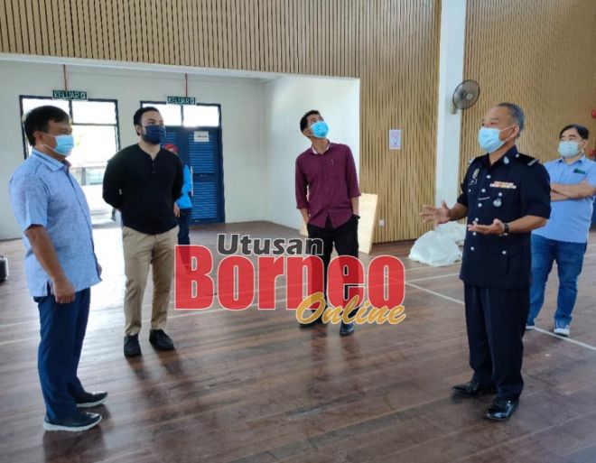 Ali (kiri) mendengar taklimat daripada Sarjan Lidam (kanan) mengenai persediaan di Dewan Balai Polis Kabong sebagai PPV yang akan mula beroperasi Isnin ini.