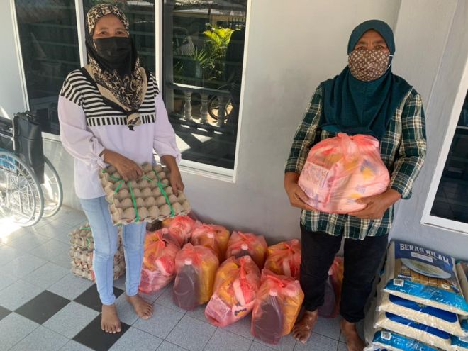 Norjanah (kanan) bersama Hajijah semasa menerima bantuan Bakul Makanan PEMULIH di bawah kawasan Parlimen Petra Jaya.