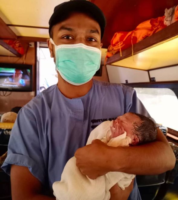 Dr Dunstan bersama bayi perempuan yang disambutnya dalam bot ekspres ketika perjalanan ke Hospital Kapit pagi tadi.