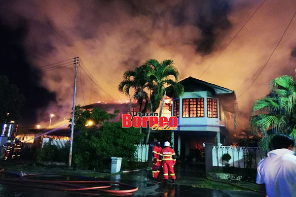  Anggota bomba berusaha memadam kebakaran membabitkan dua rumah di kawasan Teck Guan Villa.