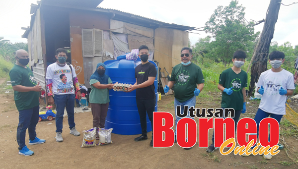  Suriani (tiga kiri) menerima bantuan tangki air dan bakul makanan daripada pasukan sukarelawan Liew yang diwakil Ketua Masyarakat Cina (Kapitan) Lim Ka Jun.