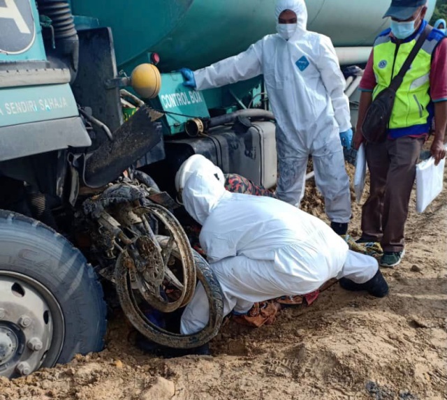  Kelihatan anggota bomba dan penyelamat sedang berusaha mengeluarkanmayat  mangsa yang tersepit di bawah lori tangki minyak dalam kemalangan berhampiran simpang Bekenu, Jalan Miri-Bintulu pagi ini.