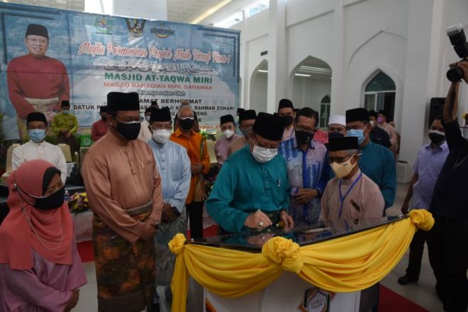 Abang Johari menandatangani plak perasmian projek naik taraf fasa satu masjid At Taqwa. -Foto Penerangan.