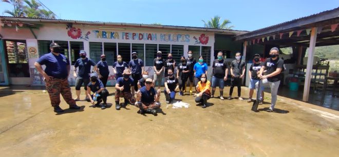  Pasukan bomba dan warga sekolah merakamkan gambar kenangan selepas aktiviti pembersihan pasca banjir.