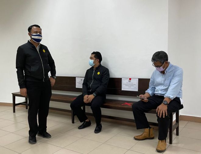  Jamal (kanan) bersama pegawai SPRM semasa berada di lobi Mahkamah Kuching hari ini.