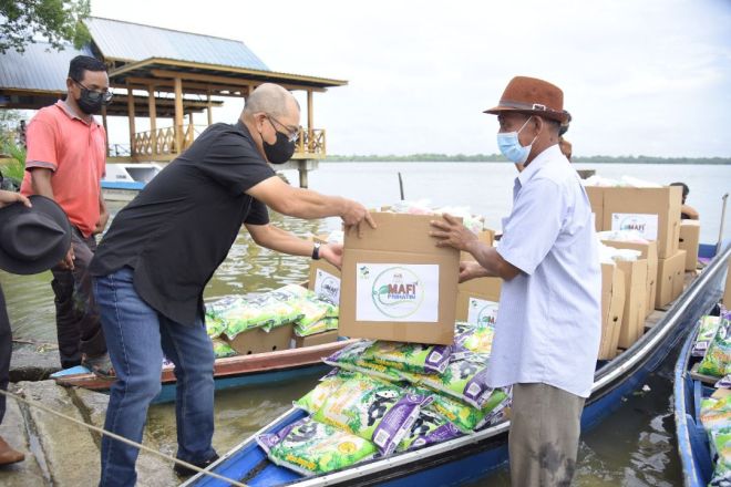  Ronald (kiri) menyampaikan bantuan MAFI Prihatin kepada wakil penduduk kampung di kawasan pulau di Beluran.