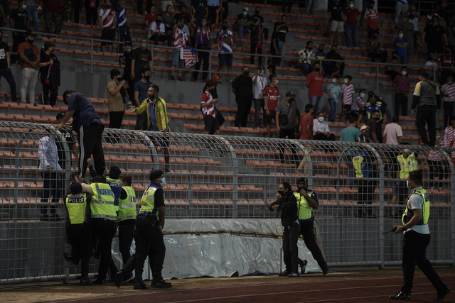 Anggota Polis Diraja Malaysia (PDRM) menahan penyokong Kuala Lumpur City FC yang merempuh masuk ke padang ketika meraikan kemenangan selepas menewaskan Selangor FC pada suku akhir kedua Piala Malaysia 2021 di Stadium Kuala Lumpur, Khamis lalu. -Gambar Bernama