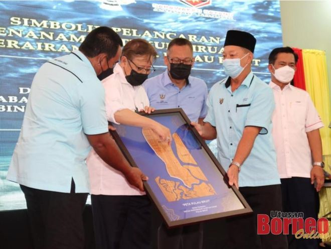 Abang Johari menerima cenderahati berupa replika peta Pulau Bruit daripada ketua-ketua masyarakat di Pulau Bruit pada Majis Pemimpin Bersama Masyarakat di Kampung Tekajong, di sini pada Khamis. Turut kelihatan, Abdullah dan Ahli Parlimen Tanjong Manis Yusuf Abd Wahab.