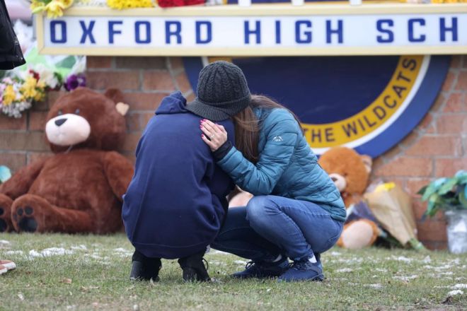  Dua pelajar dilihat berpelukan dalam kesedihan ketika melawat memorial sementara di luar Sekolah Tinggi Oxford di Oxford, Michigan kelmarin. — Gambar AFP 