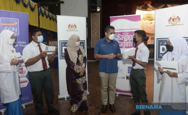 Radzi (tiga, kanan) beramah mesra dengan pelajar yang menerima tablet pada Majlis Penyerahan Sumbangan Pendidikan Digital - AEON Sayap Bagimu di Institut Pendidikan Guru Kampus Darul Aman, Jitra hari ini. -Gambar Bernama