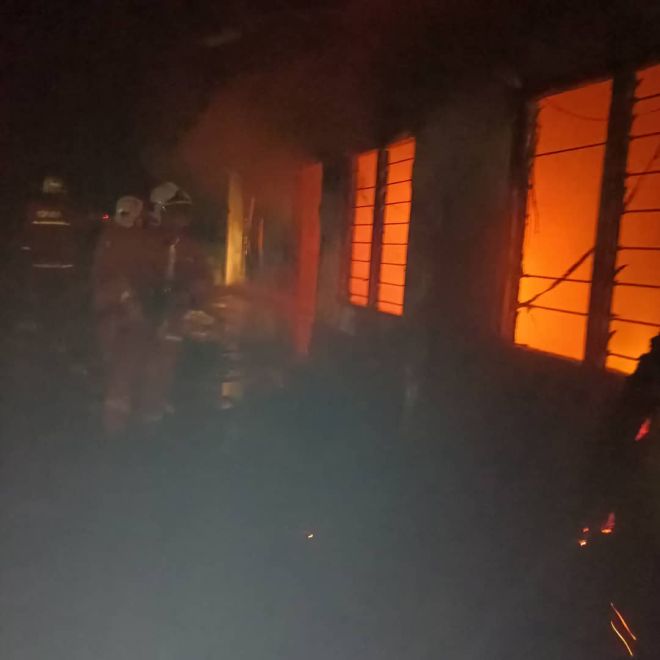  Pasukan bomba melakukan operasi pemadaman terhadap rumah PPRT yang terbakar di Papar.