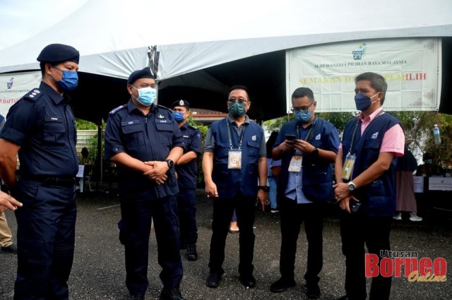 Aidi (dua kiri) bersama Ketua Polis Daerah Kuching ACP Ahsmon Bajah berjumpa dengan petugas Suruhanjaya Pilihan Raya (SPR) di pusat mengundi.