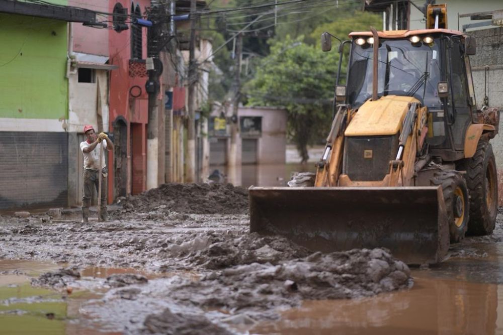Penduduk membersihkan jalan raya selepas banjir akibat hujan lebat di wilayah Minas Gerais, Brazil kelmarin. — Gambar AFP