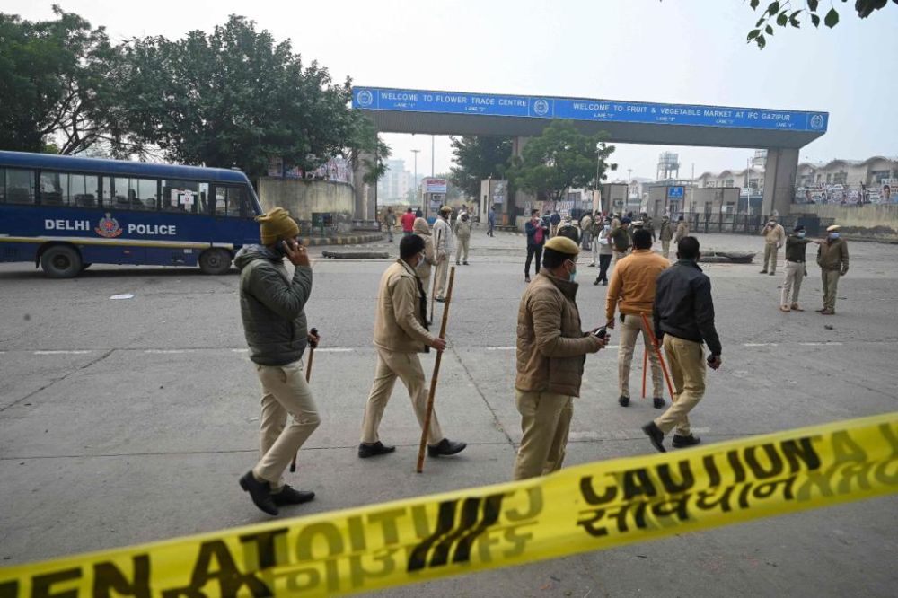 Pegawai polis New Delhi membuat sekatan ketika pakar pemusnah bom India berusaha membawa keluar bahan letupan yang ditemui terbiar di pasar bunga. — Gambar AFP