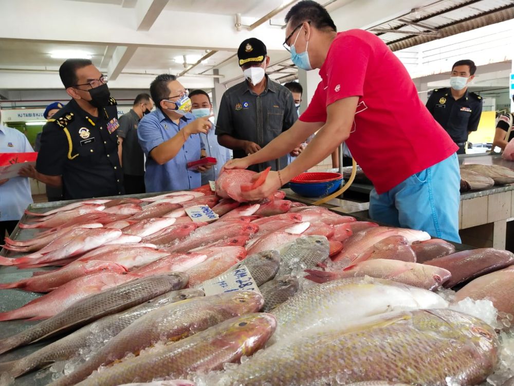 Rosol (tiga kanan) meninjau pelaksanaan dan pematuhan SHMKM oleh peniaga di Pasar Komuniti Stutong, Kuching. Turut kelihatan Azman (kiri) dan Wee (dua kiri).