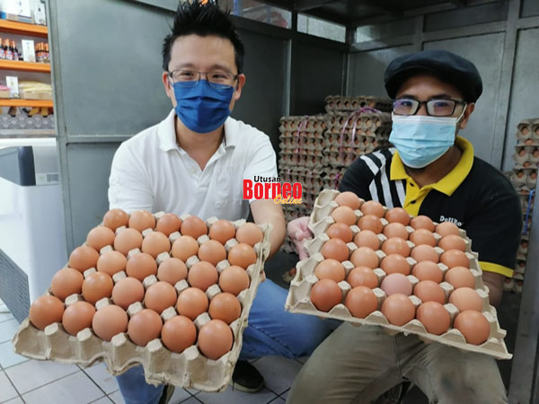  Koh (kiri) menunjukkan kekurangan bekalan telur ayam di premis perniagaannya.