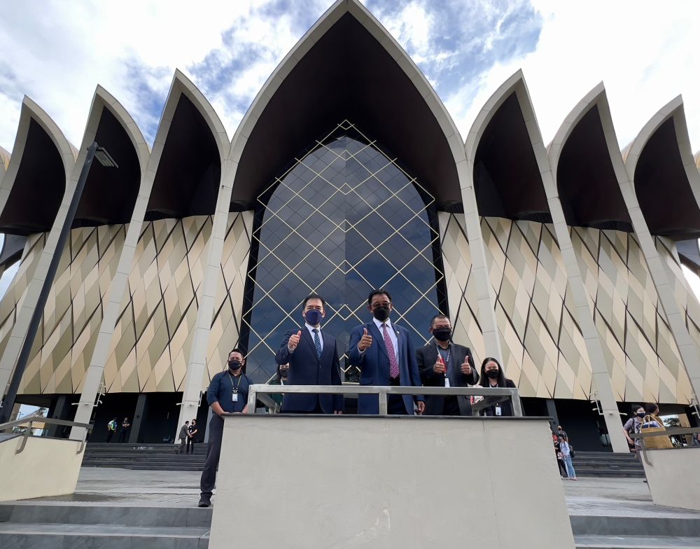 Abdul Karim bersama Hii (kiri) dan Tazudin (kanan) merakam kenangan di hadapan Muzium Budaya Borneo.