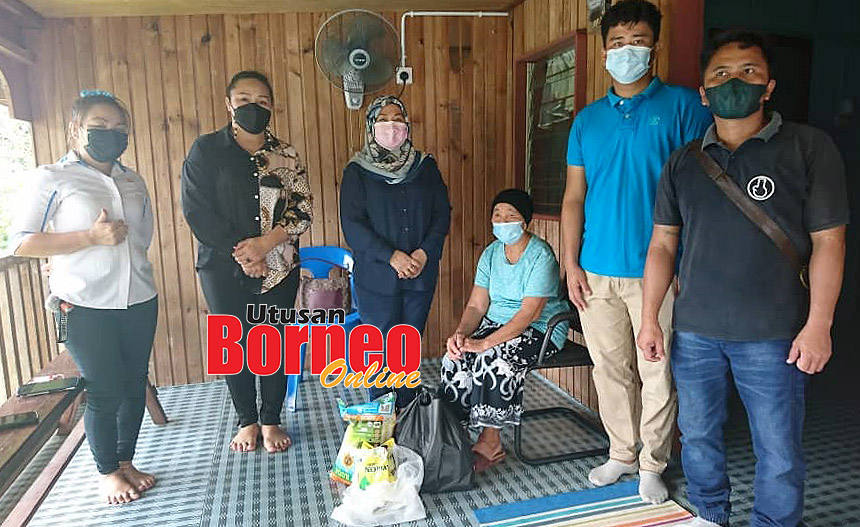  Doris (tiga kiri) bersama rombongan menyampaikan bantuan sumbangan bakul makanan keperluan makanan harian kepada Suliah Likoh (duduk) di kediamannya di Kg Sandapak.