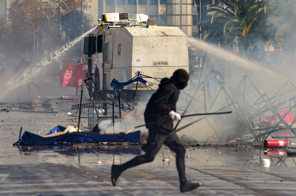 Pasukan polis menggunakan meriam air untuk menyuraikan penunjuk perasaan semasa perarakan Hari Mei di Santiago, Chile pada Ahad lepas. — Gambar AFP
