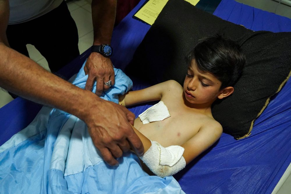 Ahli keluarga memeriksa Sipan Farhd, 9, yang cedera selepas serangan roket di rantau                                                                                              autonomi Kurdish di Iraq, di hospital di bandar Dohuk di utara Iraq kelmarin di mana dua kanak-kanak dilaporkan terbunuh. — Gambar AFP