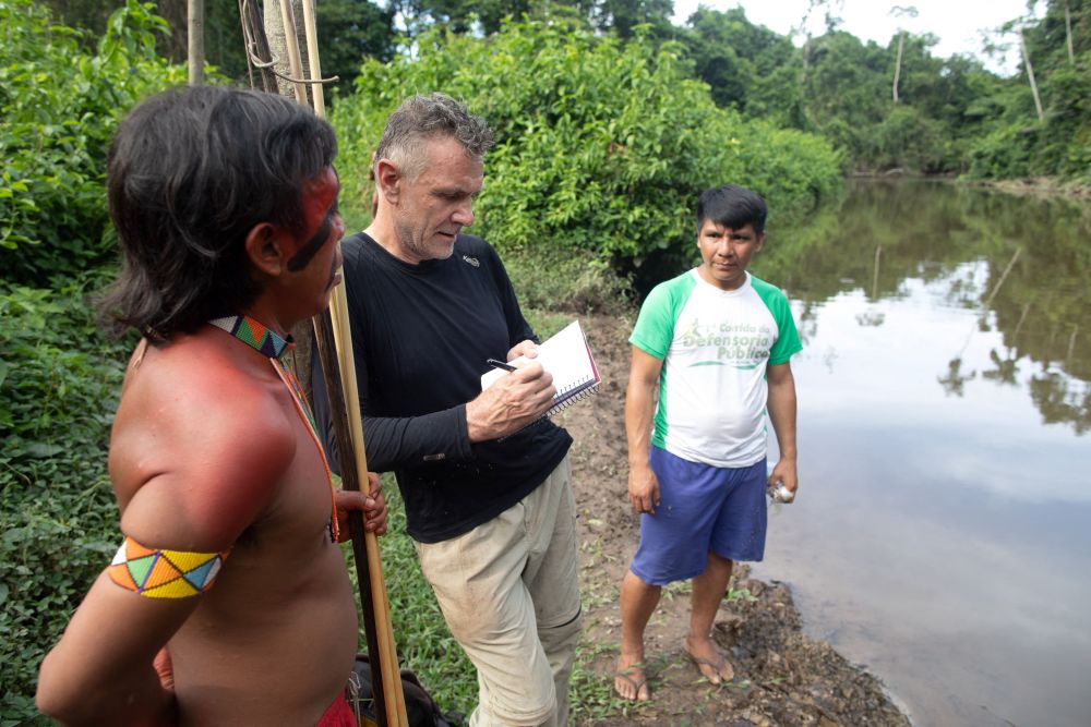 Gambar bertarikh 16 November, 2019 menunjukkan Phillips (tengah) bercakap dengan dua lelaki peribumi di Aldeia Maloca Papiu, Brazil. — Gambar AFP