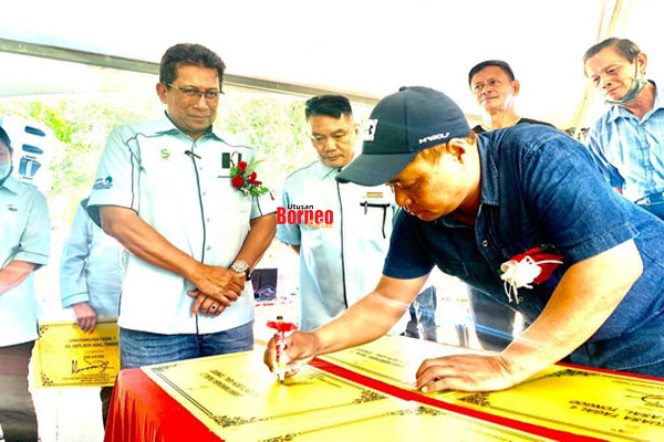 Masiung (kanan) menandatangani papan tanda Tagal Tradisi sambil disaksikan oleh Timbalan Pengarah Jabatan Perikanan Sabah Azhar Kassim (kiri).